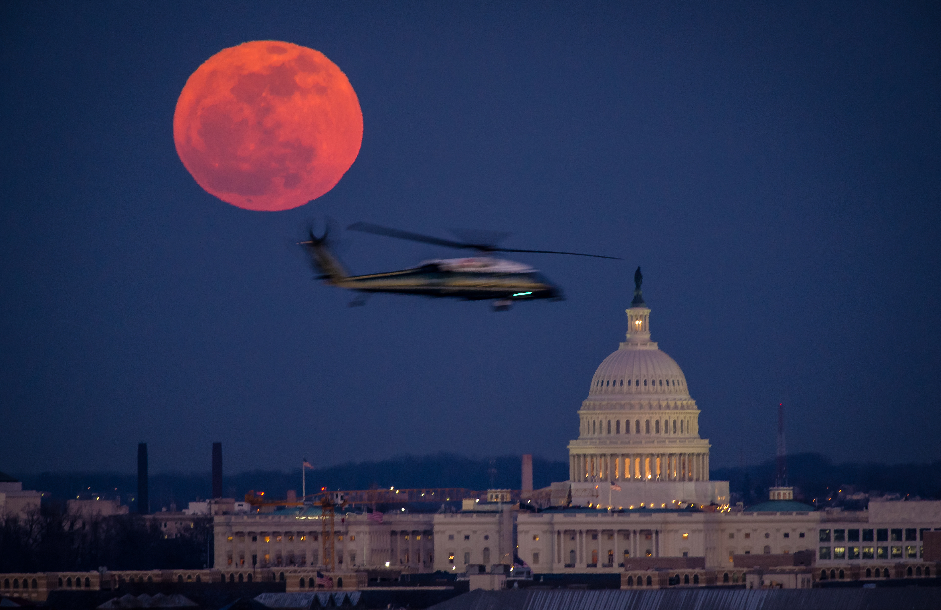 Se ve un helicóptero del Cuerpo de Marines de EE. UU. volando a través de esta vista de la luna llena y el edificio del Capitolio de EE. UU. el martes 7 de febrero de 2012 desde el Cementerio Nacional de Arlington