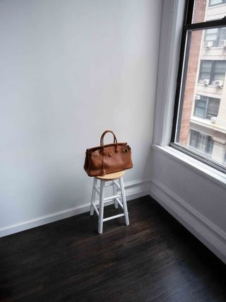 Brown Louis Vuitton handbag on stool