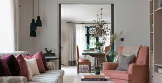 traditional drawing room with pink upholsetred furniture with pocket doors leading through to the room beyond