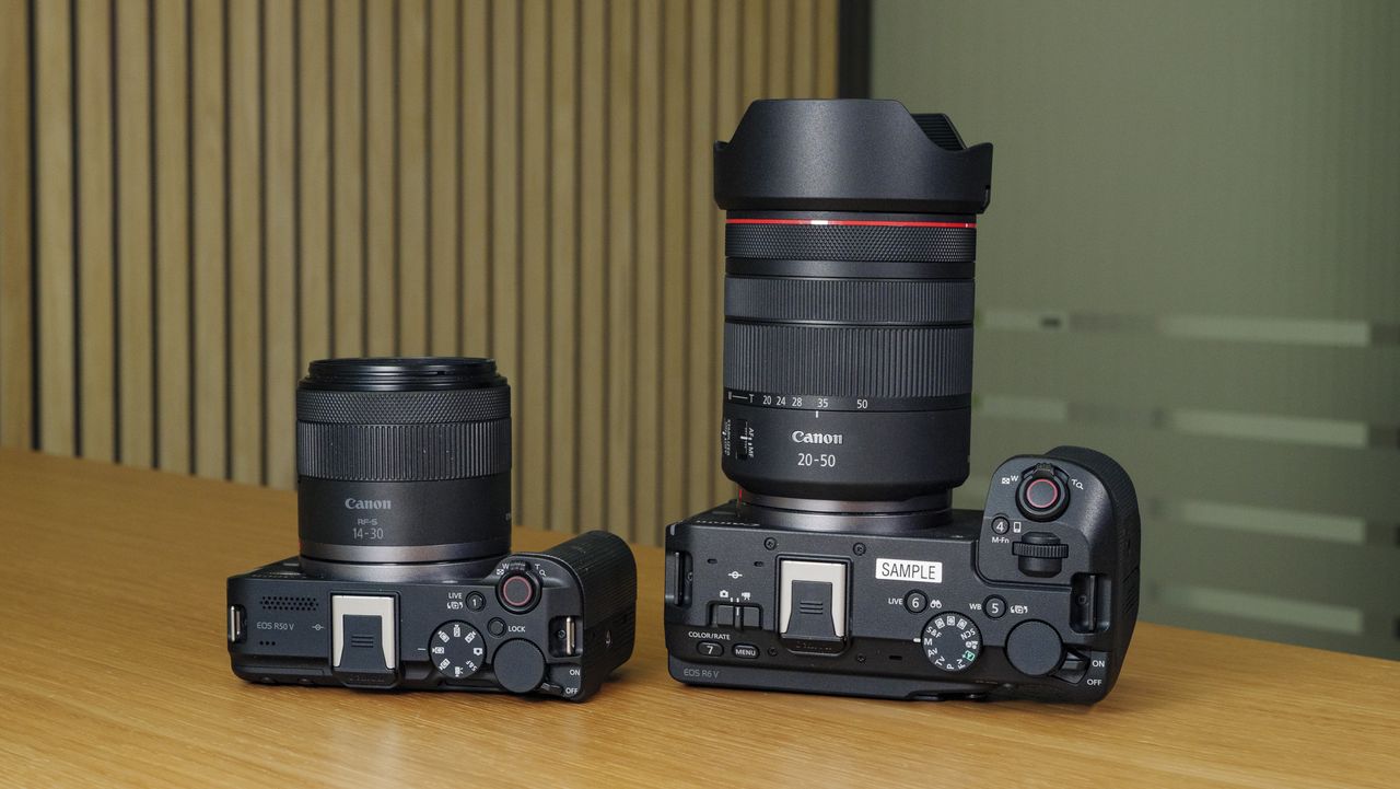 The Canon EOS R6 V on a wooden table alongside the Canon EOS R50 V