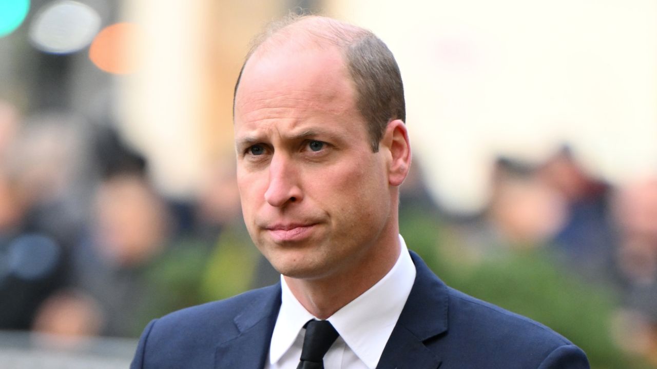 Prince William grimaces while wearing a suit, he has a balding head