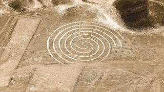 Aerial photo of Nazca lines in Peru. This geoglyph looks like a line drawing of a spiral.