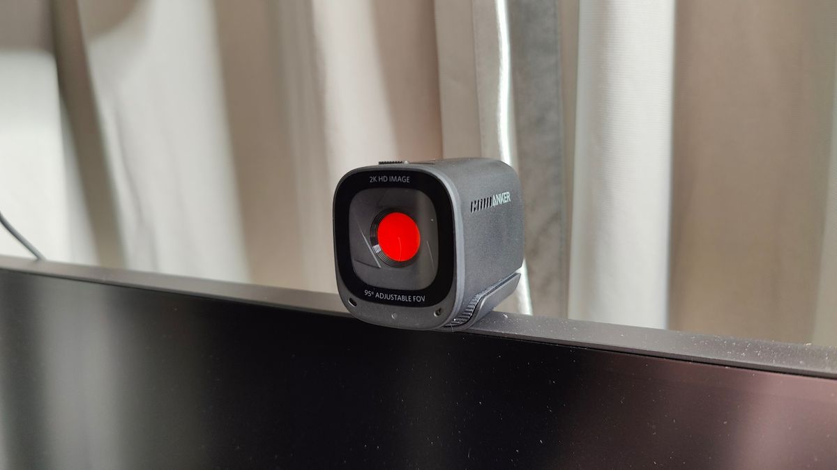 Angled photo of Anker PowerConf C200 webcam mounted on a monitor with red privacy shutter engaged