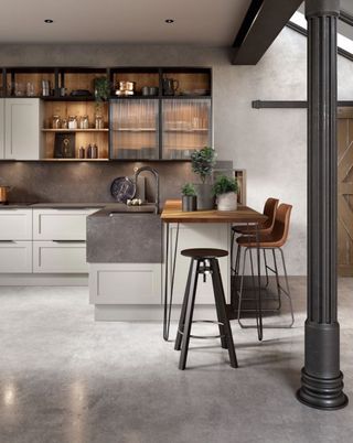 Kitchen renovation cost in an industrial style scheme with gray concrete flooring and wooden peninsula breakfast bar.