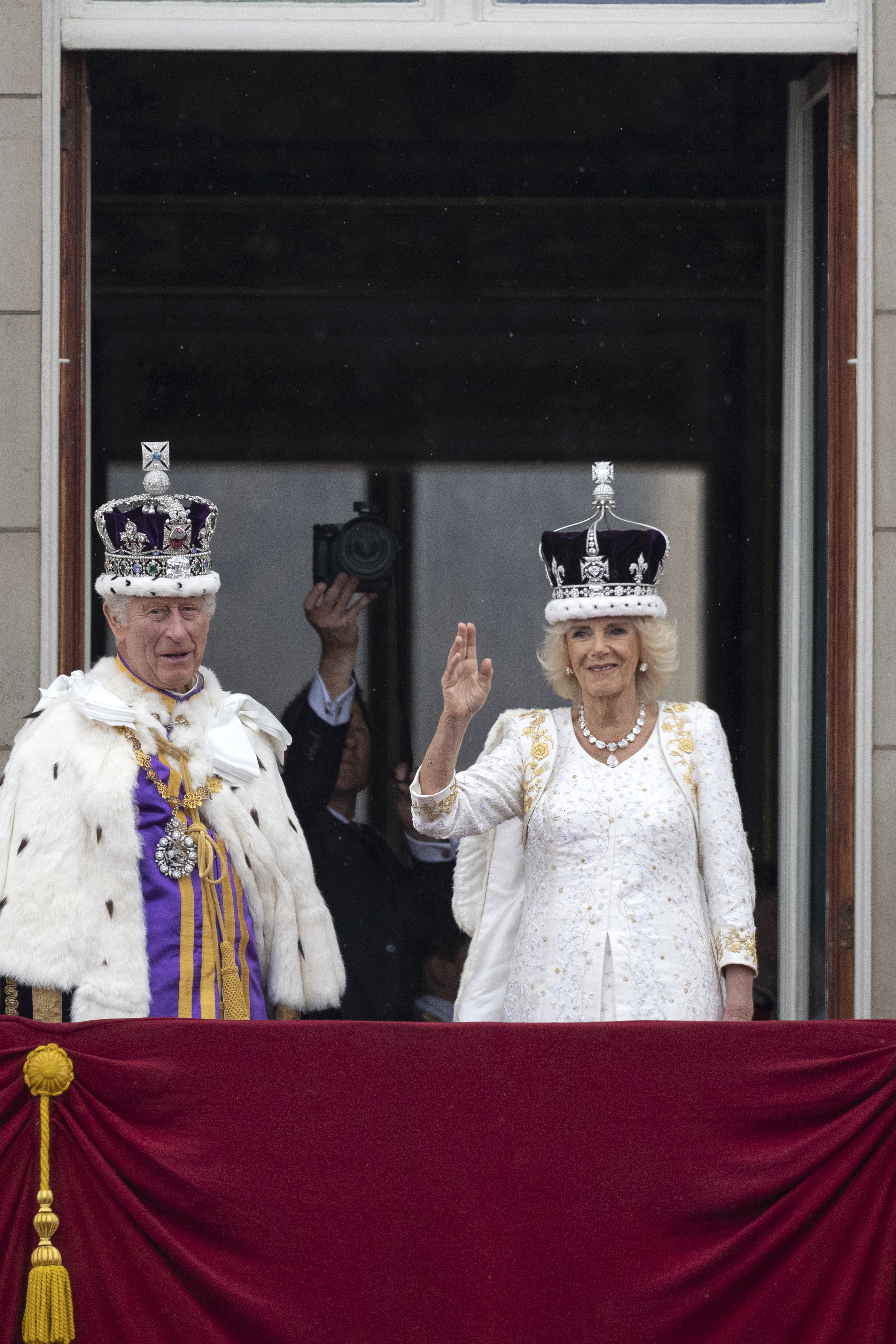 King Charles and Queen Camilla waving from the balcony in their coronation outfits