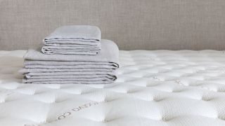 Saatva Zenhaven review: linens pictured on top of an unmade Zenhaven mattress