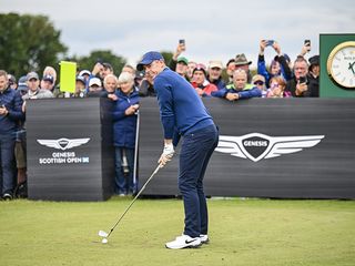 Rory McIlroy preparing to hit a long iron off the tee at the Genesis Scottish Open