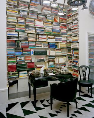 A floor to ceiling bookcase behind a black desk at Karl Lagerfeld's Paris apartment