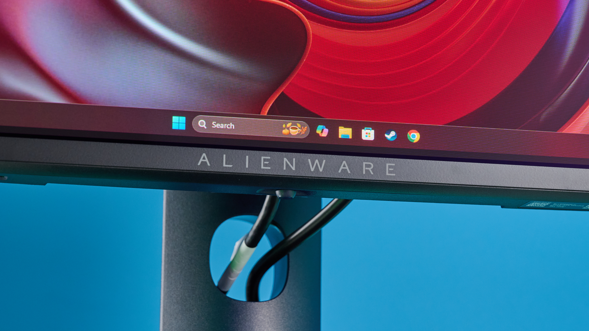 Alienware AW2725D on a desk against a blue background