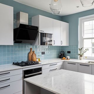 kitchen with white and blue wall white cabinets and white counter