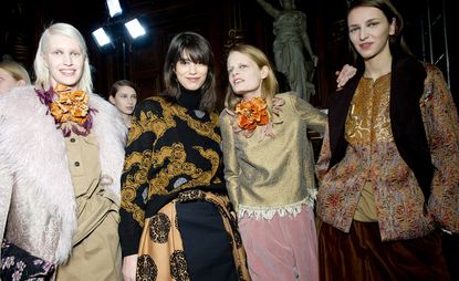 Four female models in a range of brown and cream tones with metallic and fur details