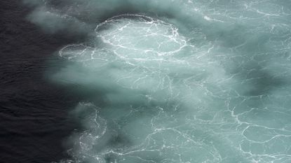 A photo of water churning off the coast of Streymoy in the Faroe Islands.