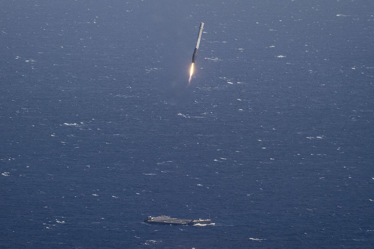 SpaceX's Falcon 9 rocket first stage is seen descending toward its drone ship landing pad in the Atlantic Ocean in this view from a chase plane captured on April 8, 2016.