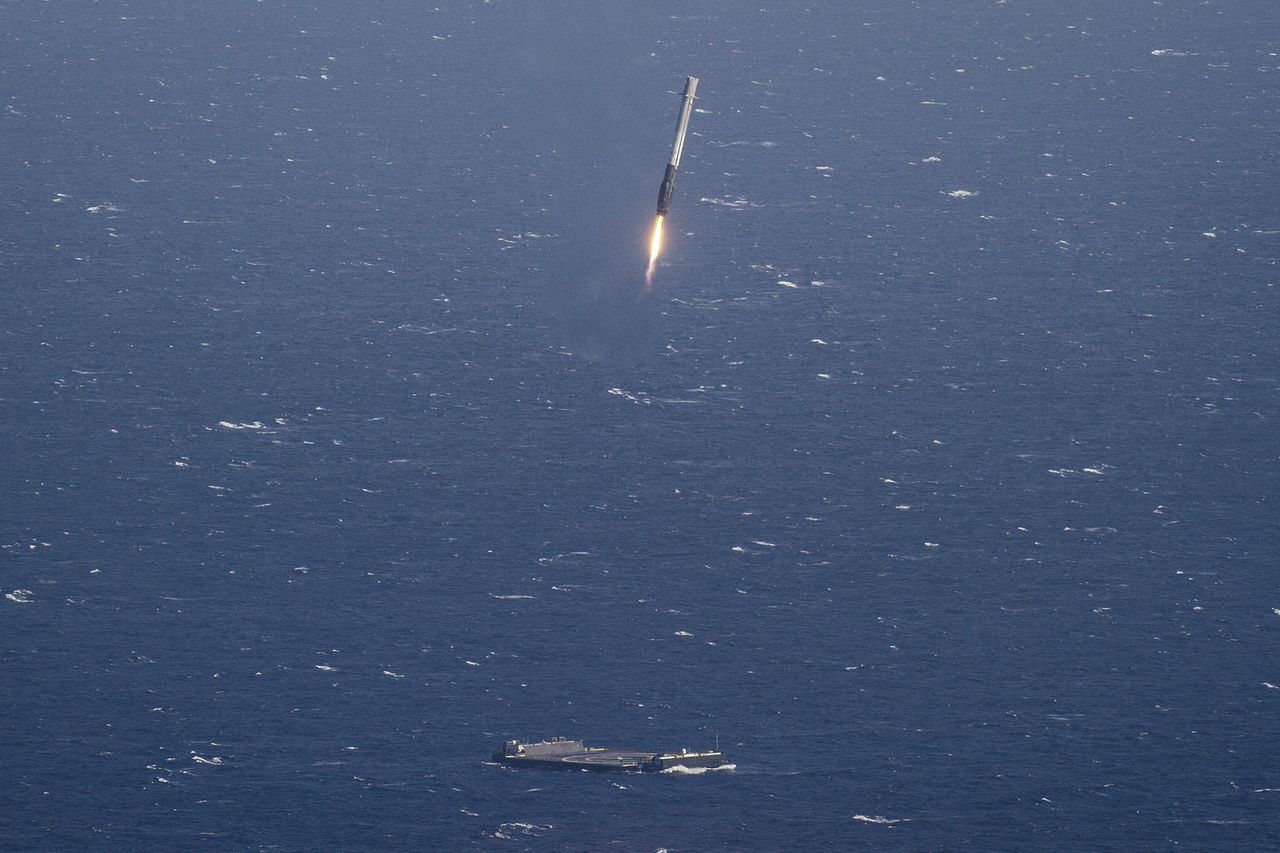 SpaceX's Falcon 9 rocket first stage is seen descending toward its drone ship landing pad in the Atlantic Ocean in this view from a chase plane captured on April 8, 2016.