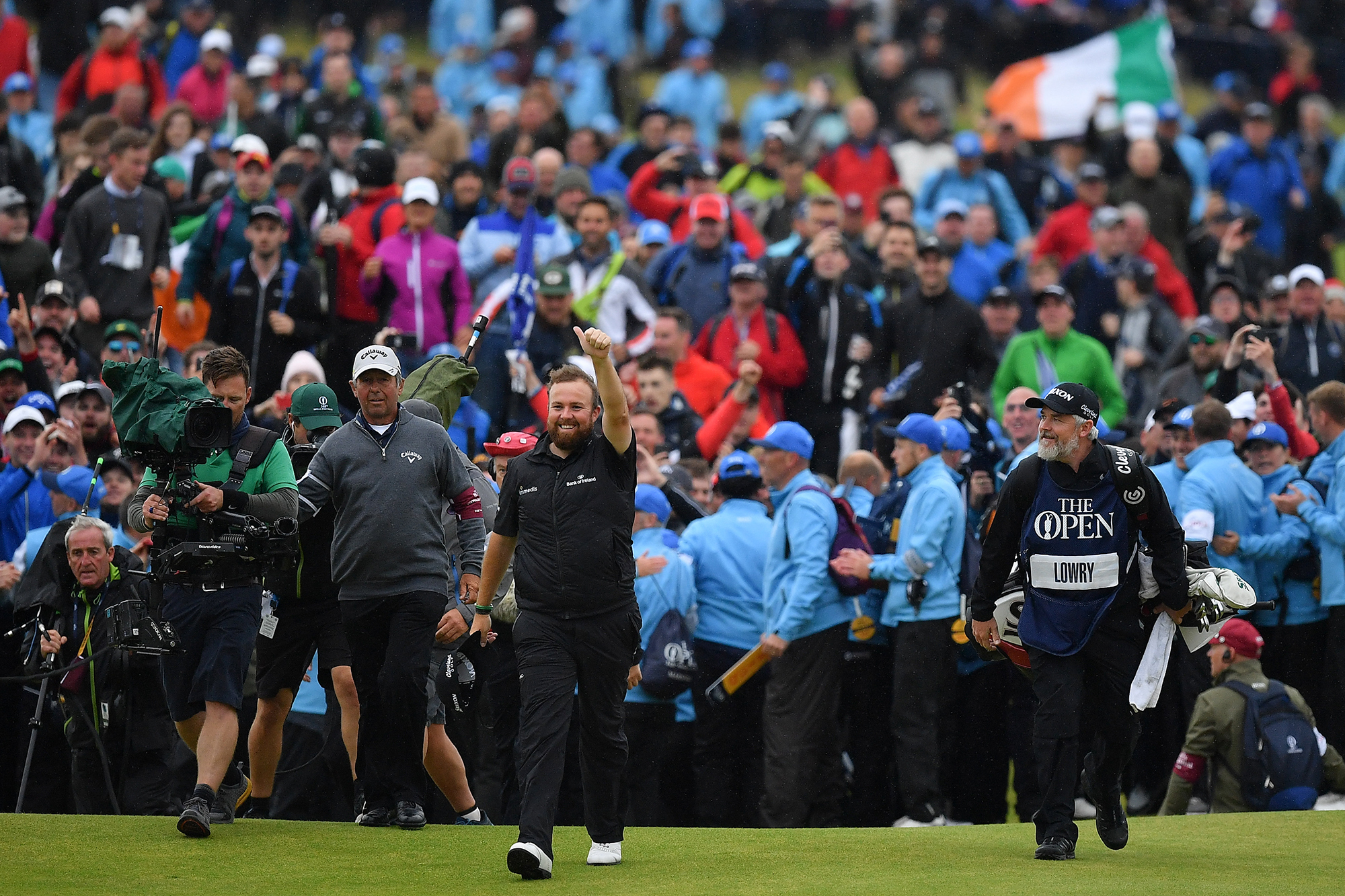 Shane Lowry walking in front of a huge crowd of fans at the 2019 Open Championship, as he makes his way up the 18th fairway at Royal Portrush on his way to winning the Open Championship