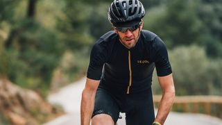 Person riding a bike wearing a Le Col cycling jersey