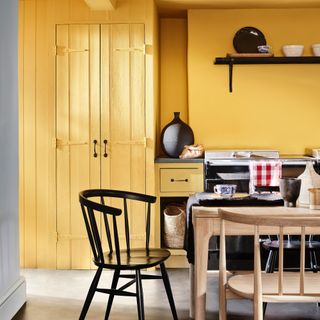 should rooms be painted in light or dark colours, yellow kitchen dining space, blond wood table and chairs, black chairs, black age, black accents