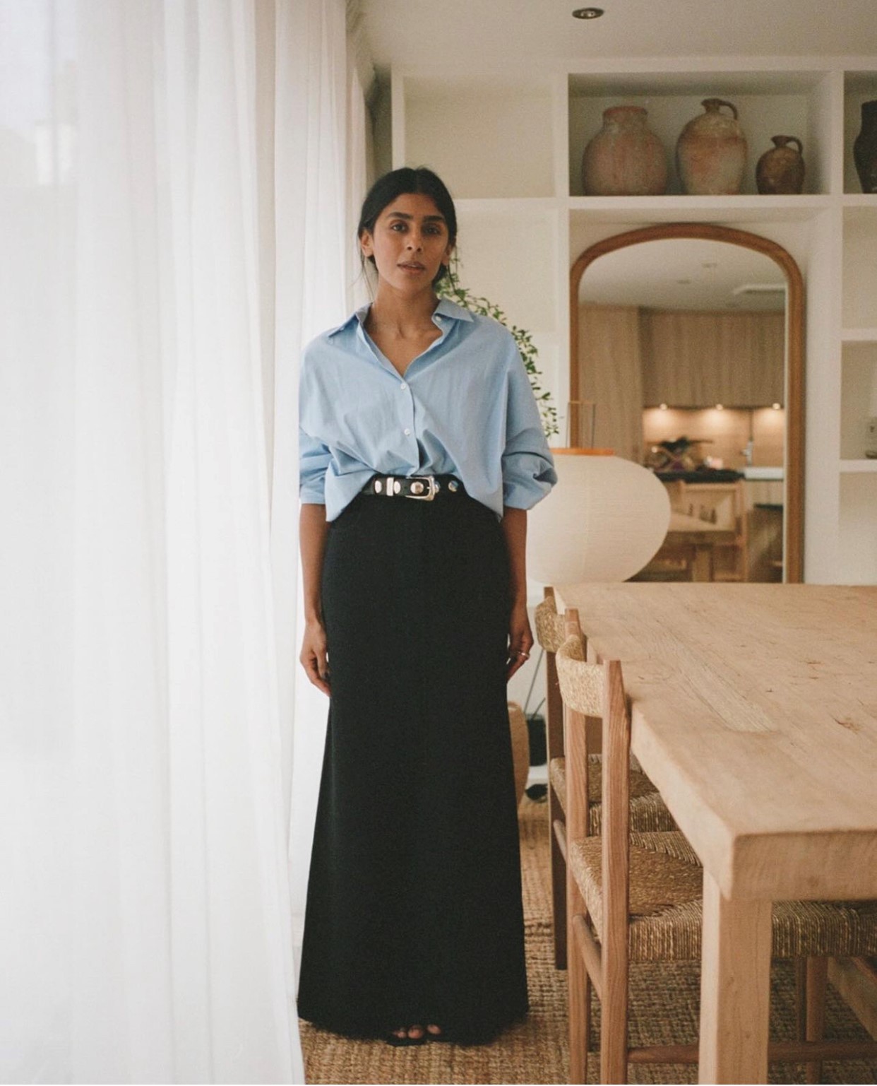 Monikh wears a blue shirt and black maxi skirt