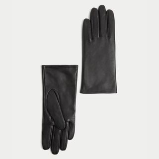 Cutouts of black leather gloves from M&S against a pale grey background