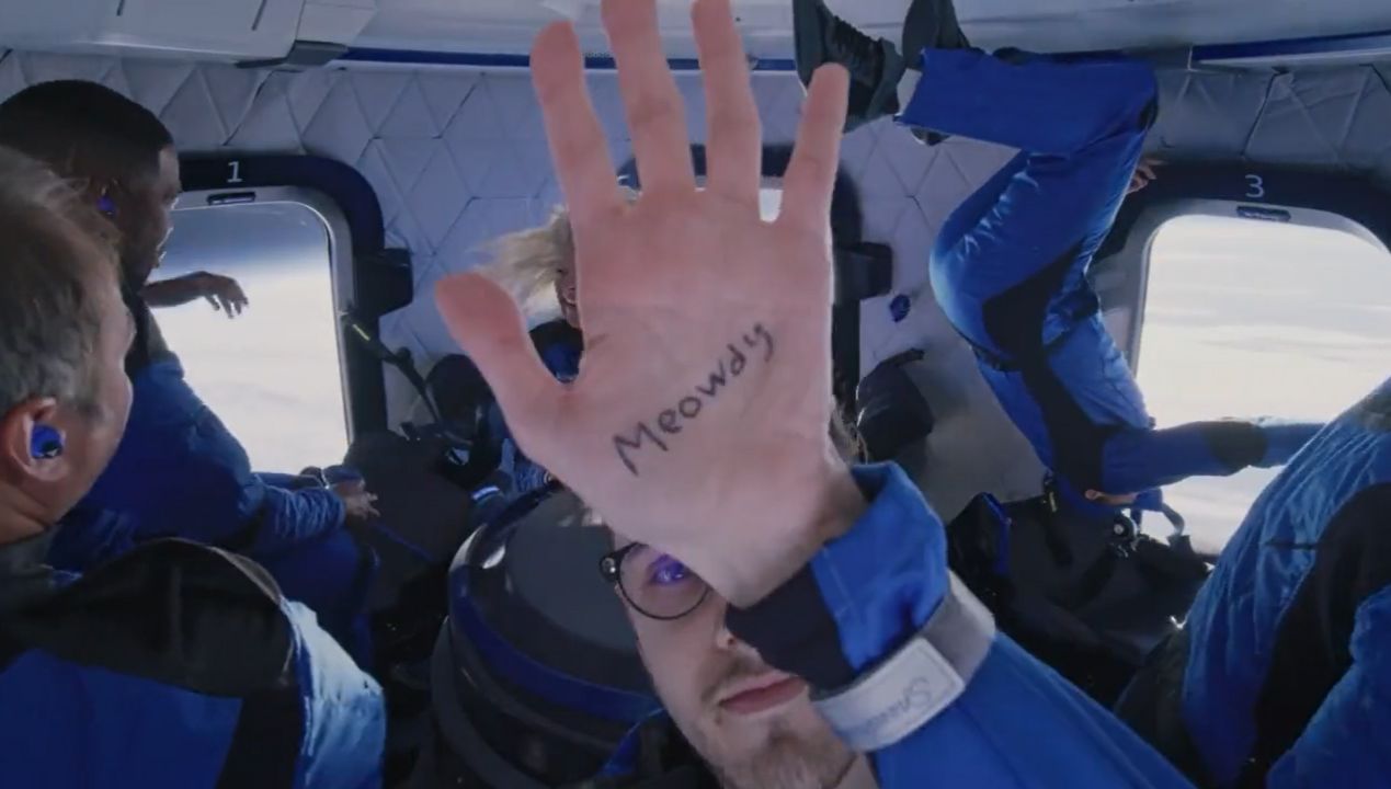 Blue Origin New Shepard NS-19 passenger Cameron Bess holds up a "Meowdy" message while floating in weightlessness during their suborbital spaceflight on Dec. 11, 2021.