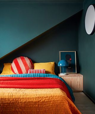 Dark green loft bedroom with bright colored bedding