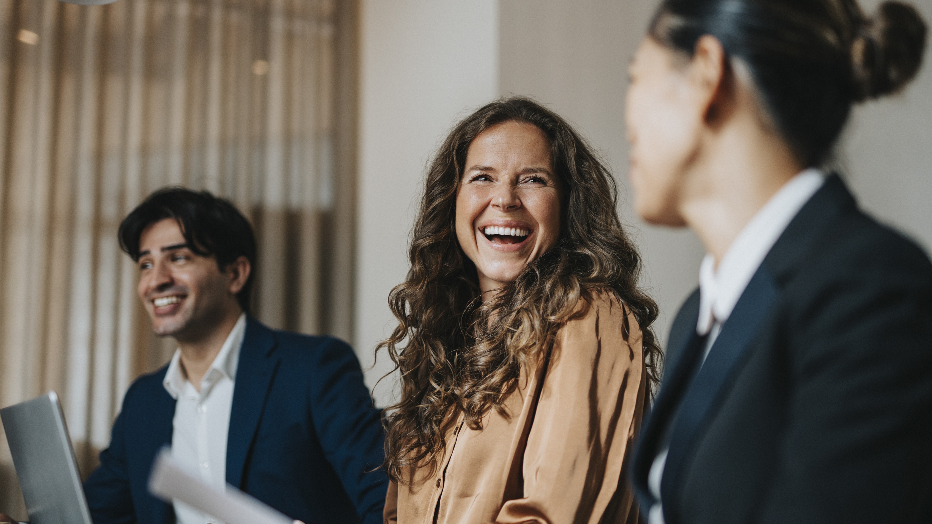Three financial advisers interact during an office meeting.