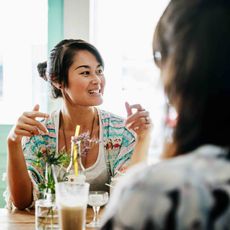 Table, Happy, Drink, Tableware, Black hair, Drinkware, Alcoholic beverage, Necklace, Distilled beverage, Highball glass, 