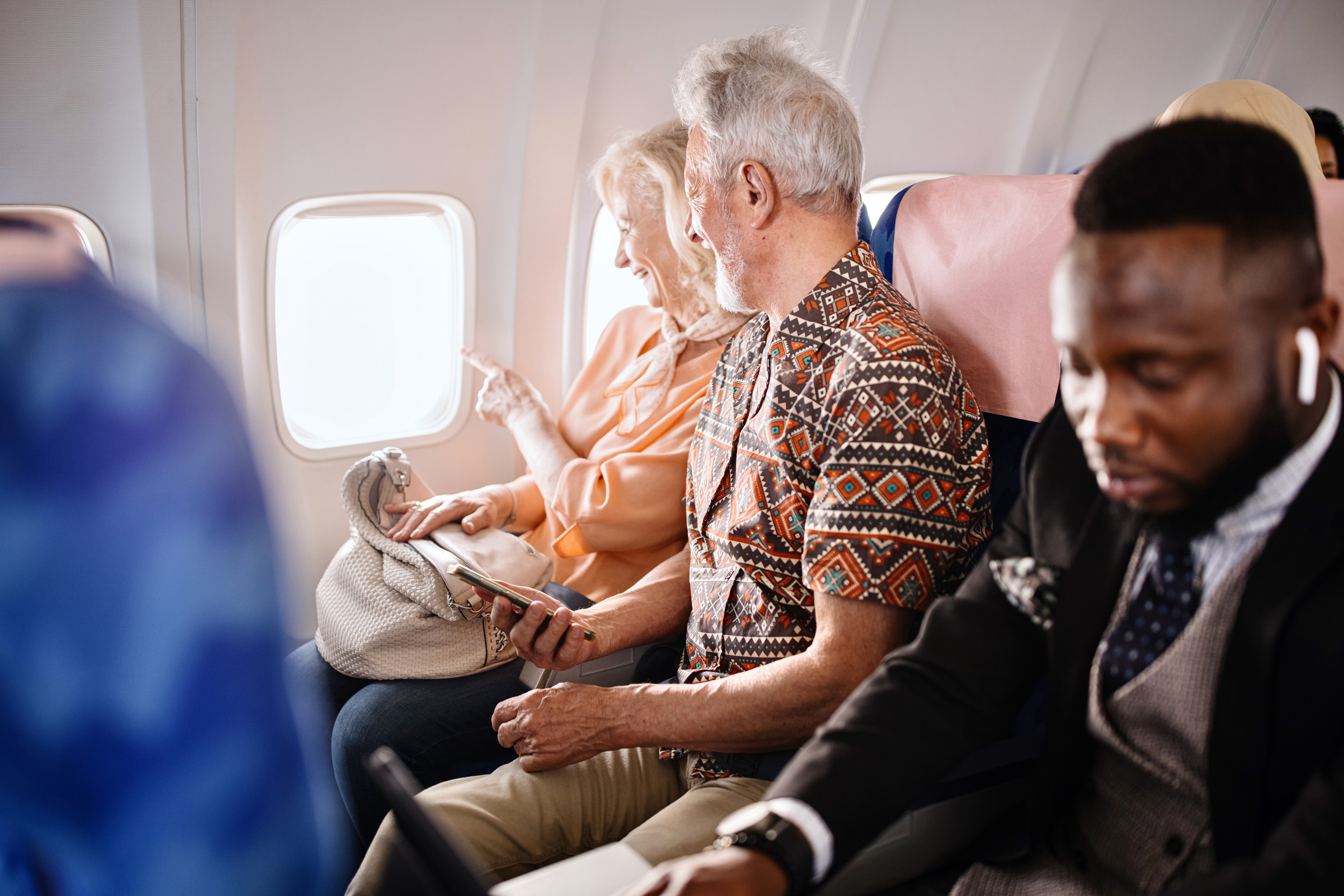A senior couple sitting on an airplane.