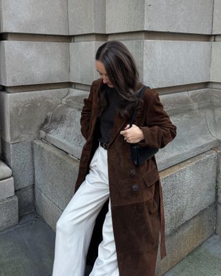 Liv Perez wearing a Madewell x Alexa Chung trench coat with a black top and white jeans.