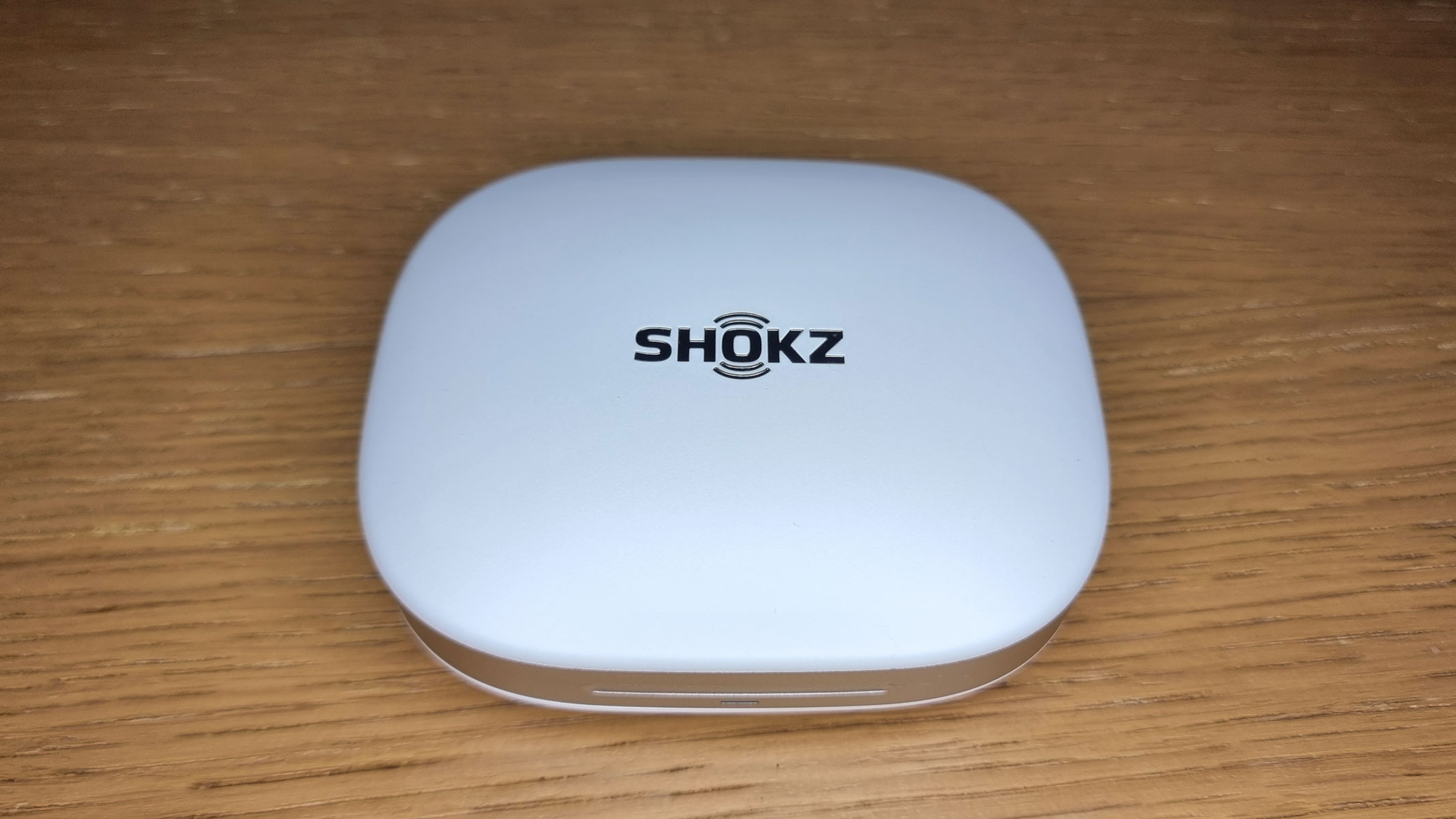 A closed charging case for the Shokz OpenFit Pro earbuds