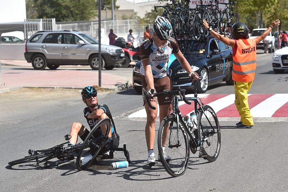 Vasil Kiryienka watches on as Gediminas Bagdonas remountrs his bike