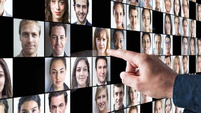 A man points at a woman's photo among many on a digital display.