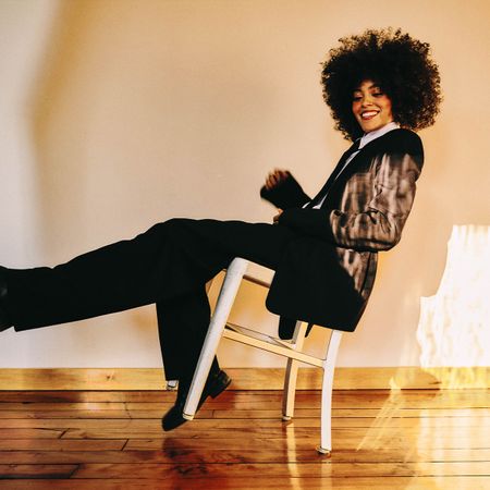 Photo of Quintessa Swindell wearing Tibi blazer and pants, Polo Ralph Lauren button down shirt, Calvin Klein tie, and Ann Demeulemeester boots.