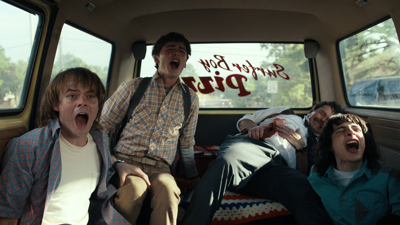 Jonathan Will and Mike scream with a bloodied man in the back of a van in Stranger Things