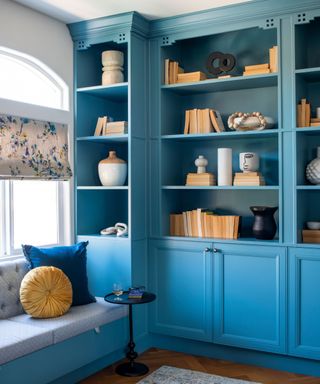 blue custom bookcase shelving with reading nook seat and decorative accessories