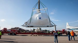 NASA's Orion capsule, wrapped up for transport, is guided toward the Super Guppy.
