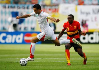 Ali Daei (left) in action for Iran against Angola at the 2006 World Cup.