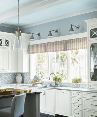 Bright kitchen with white cabinetry and a light blue ceiling