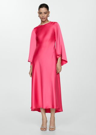 A model wears a bright pink satin midi dress with long flowing sleeves