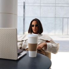 Rochelle Humes sitting and working on a laptop with a cup of coffee