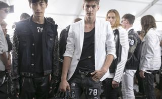 Busy room full of models wearing monochrome clothing