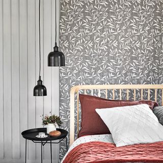 Grey bedroom with botanical wallpaper, red bedding and twin pendant lights