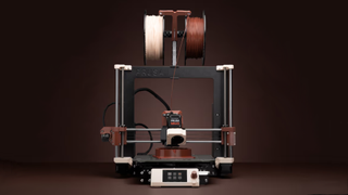 A 3D printer is shown using the new beige and brown 3D printing filaments from Noctua and Prusa Research.