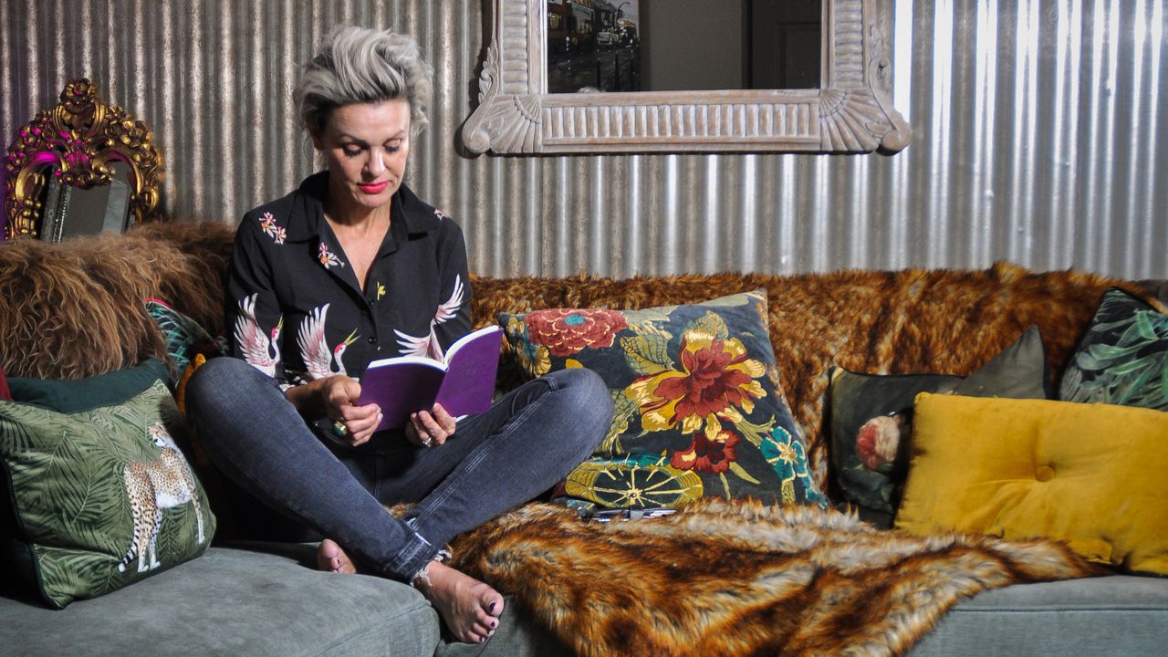 Sarah Parmenter sitting on sofa in her metallic living room