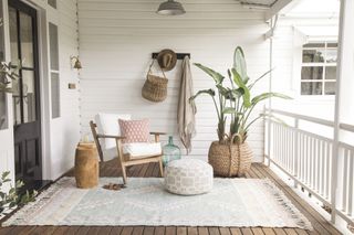 A porch with a rug and soft furnishings