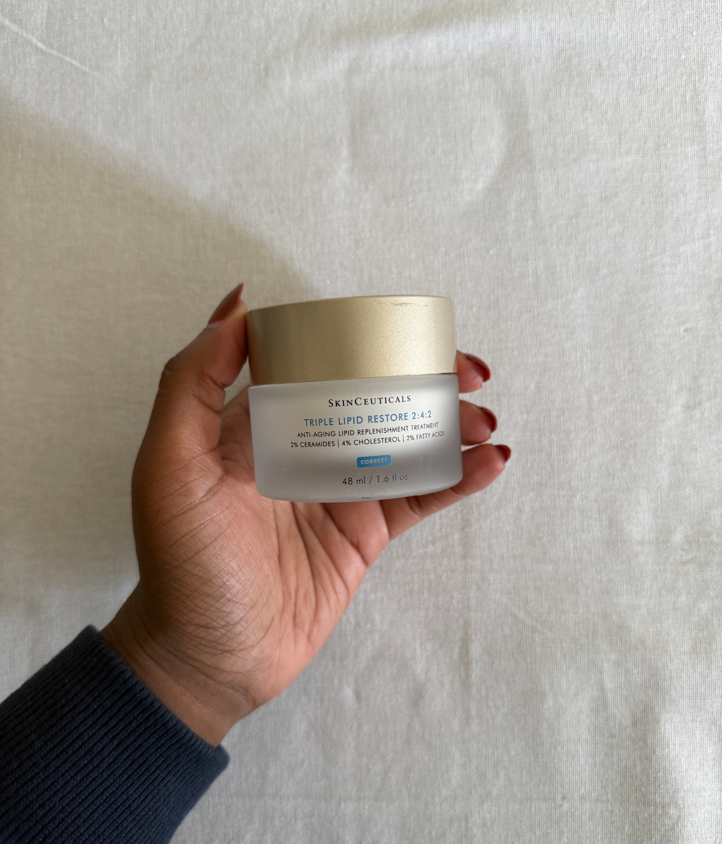 Associate Beauty Editor Maya Thomas holding the SkinCeuticals Triple Lipid Restore 2:4:2 Moisturizer Cream