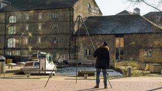 Gitzo Giant tripod extended and towering above a photographer