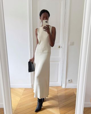 Influencer styles a silk dress with heeled boots.