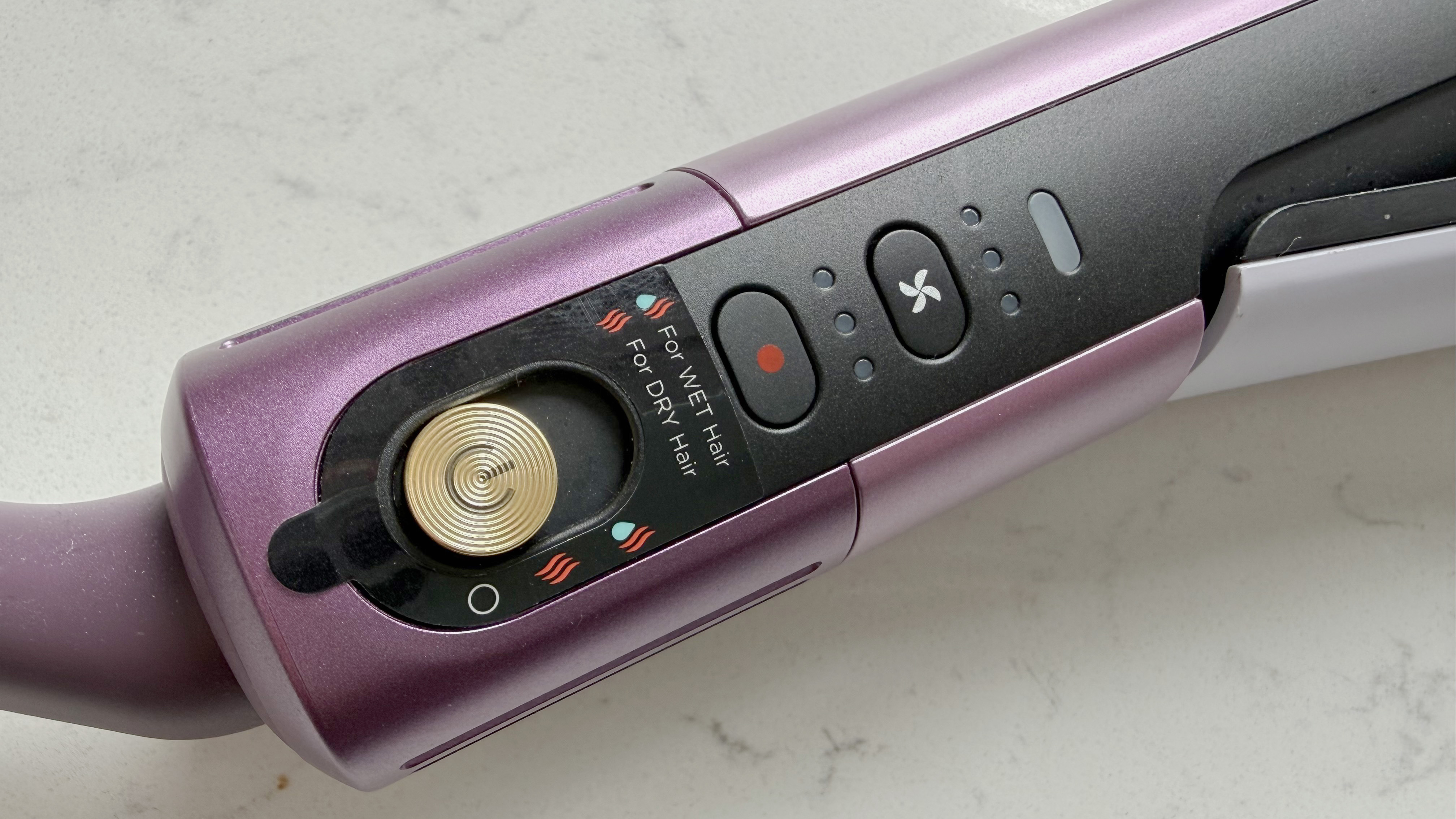 Close-up of the Shark SilkiPro Straight controls showing the gold power button, wet/dry mode toggle, and airflow and temperature buttons on the lower body