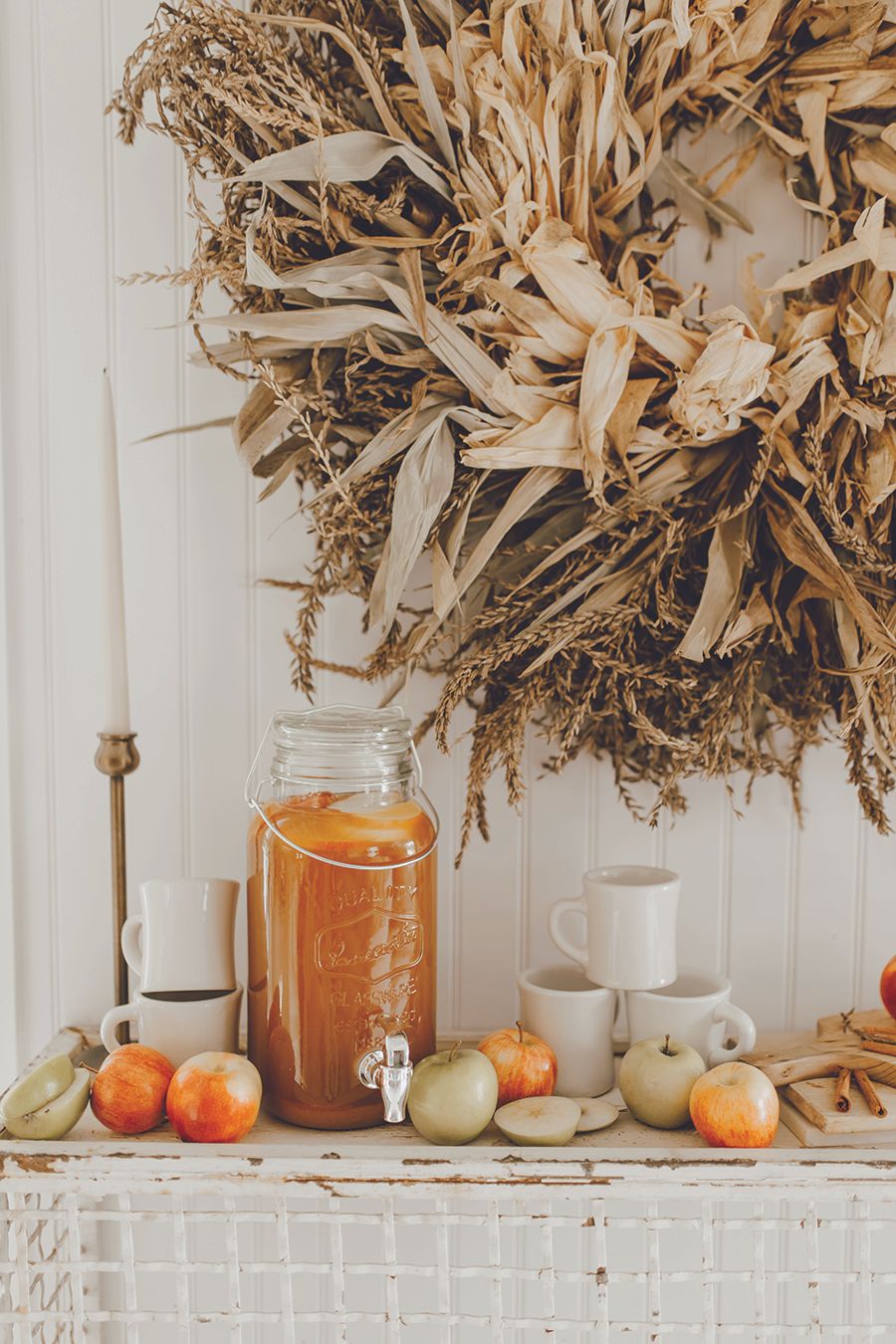 Thanksgiving apple cider bar idea with wreath, apples and cinnamon sticks